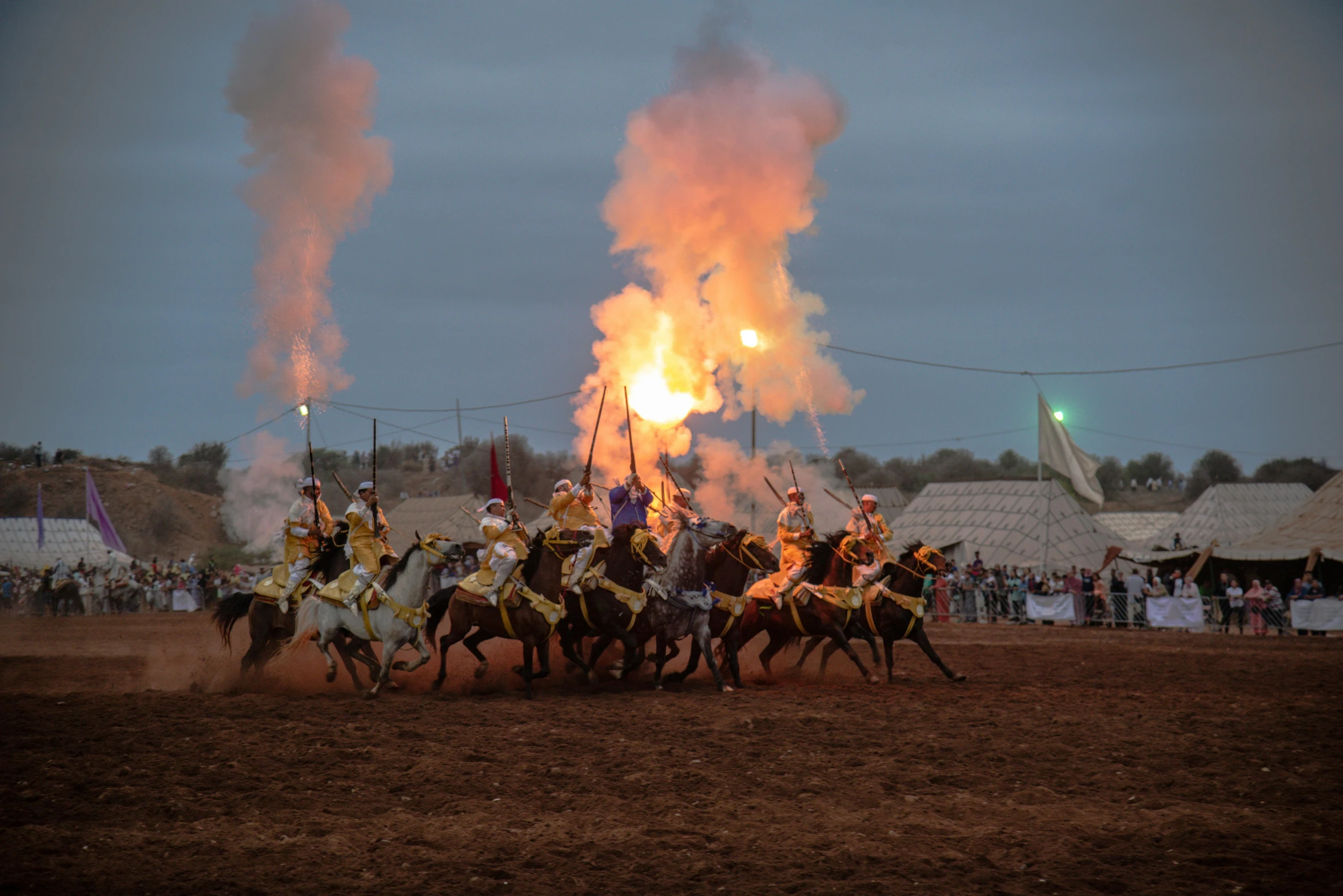 men on horses in medieval costume and helmets are kicking up a group of flames