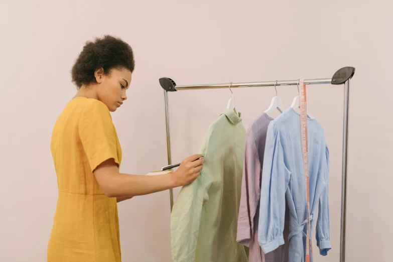 a person holding a cell phone near a rack of clothes