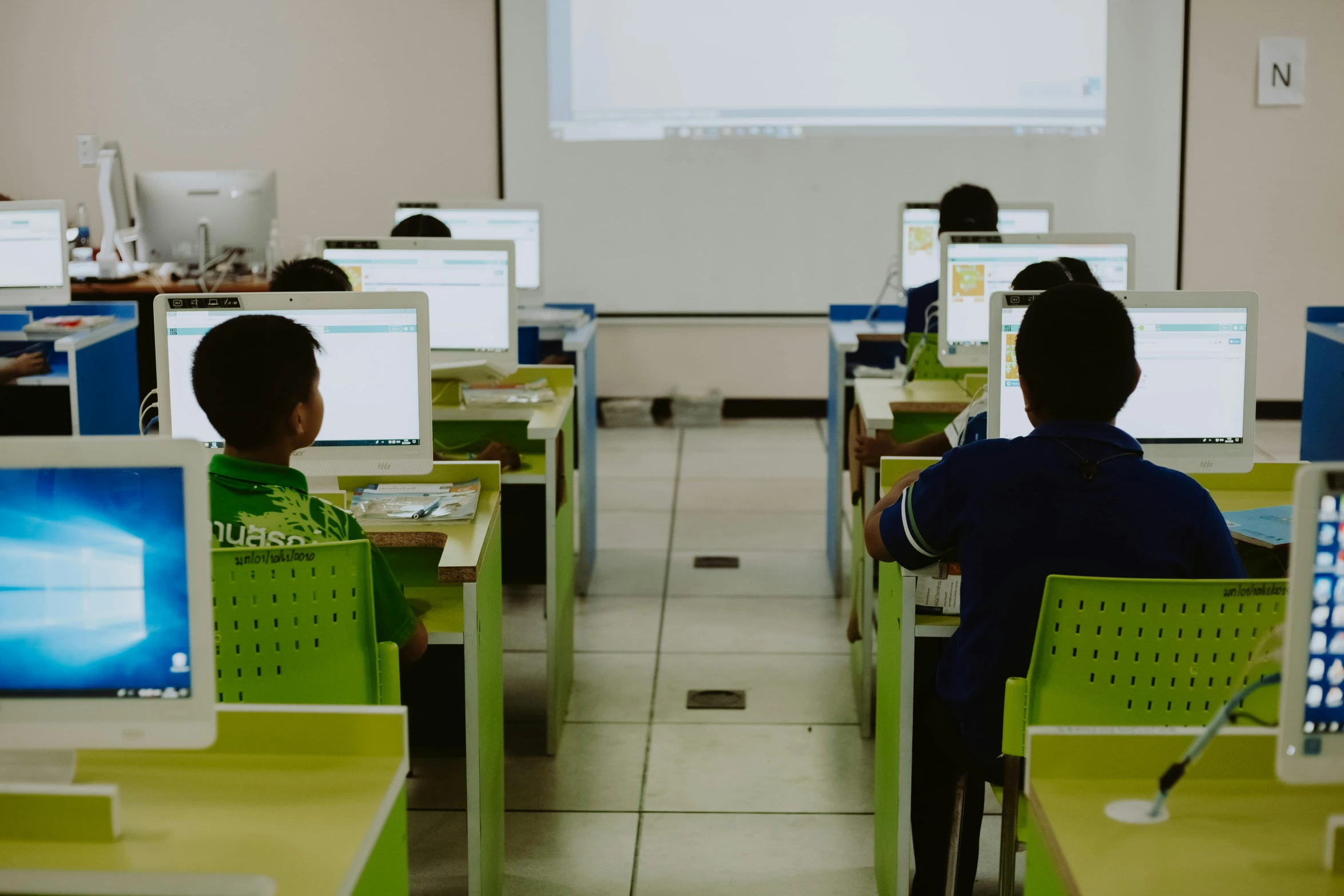 students use computers in the computer lab with a projector