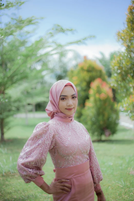 a woman in pink with pink dress and hijab posing