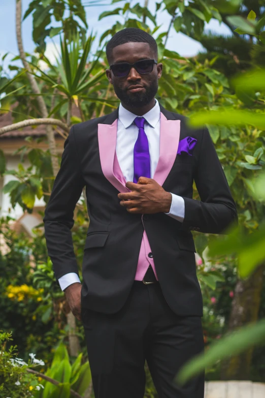 a man wearing a pink tie with sunglasses on his face