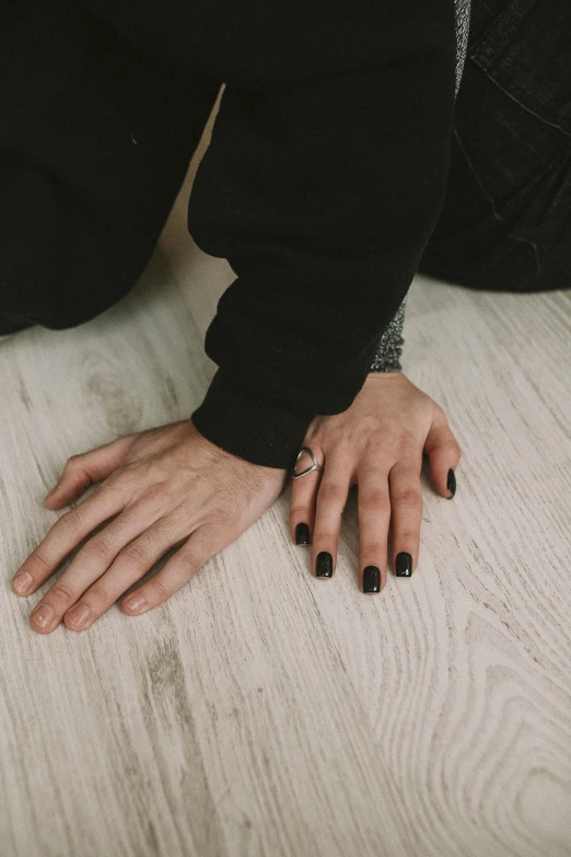 a persons hands with nails on them sitting on a bed