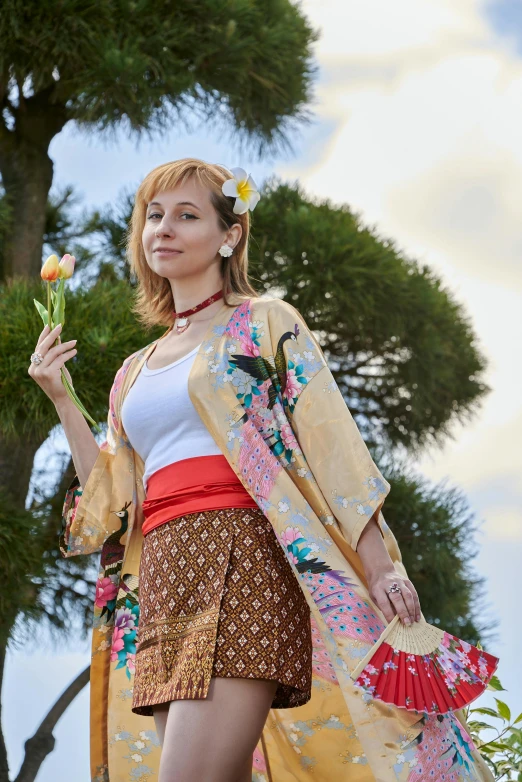 the woman is wearing a flower and carrying a fan