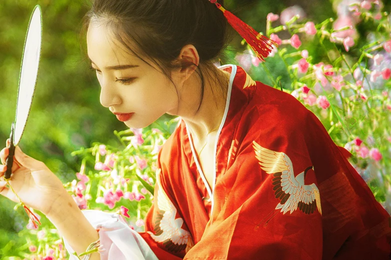 an asian girl in red holding a pair of scissors