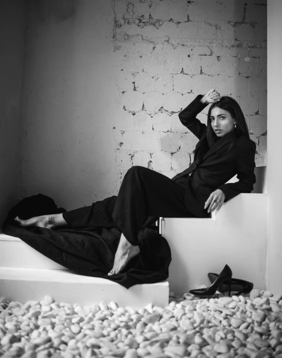 woman sitting on a ledge in a room with white rocks and walls