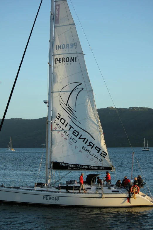 a sail boat sailing on a calm blue ocean