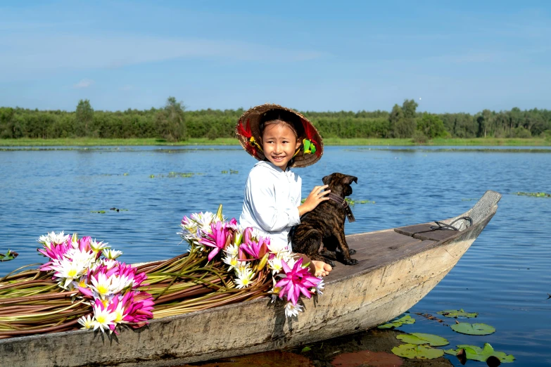 a girl sitting on a boat holding a dog