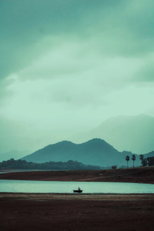 there is a boat in the water and mountains in the distance