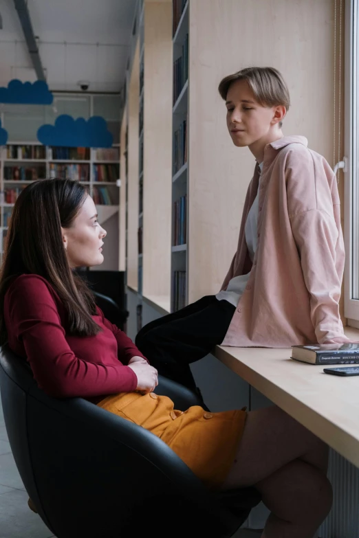 a woman and a child at a liry while one sits down and talks to the other