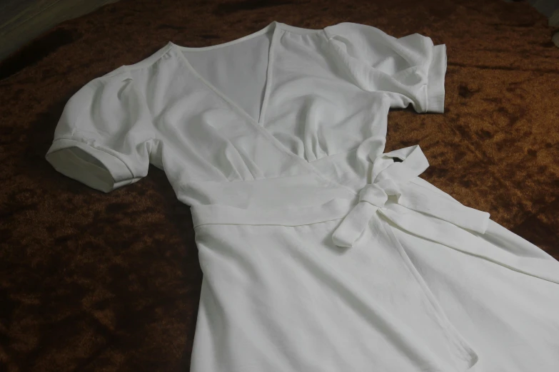 white clothes laying on the ground next to a brown rug
