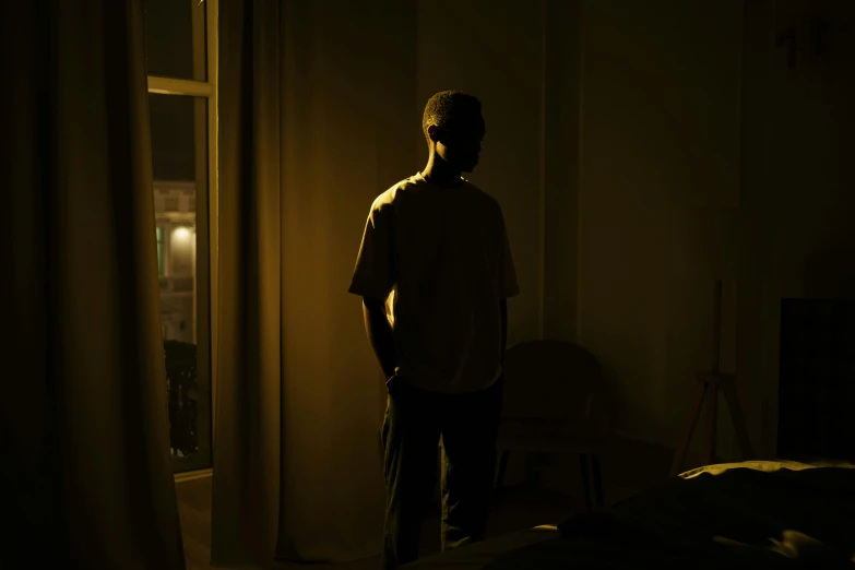 the dark room shows the shadow of a man in a white shirt