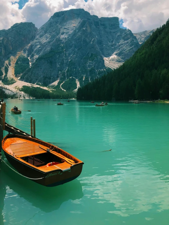 a boat floating on a lake surrounded by mountains