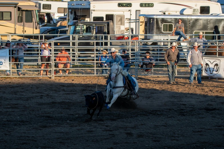 a cowboy is riding a bucking bronco while others watch