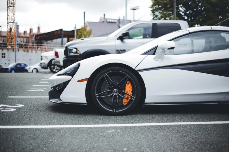 two white sports cars are parked in a parking lot