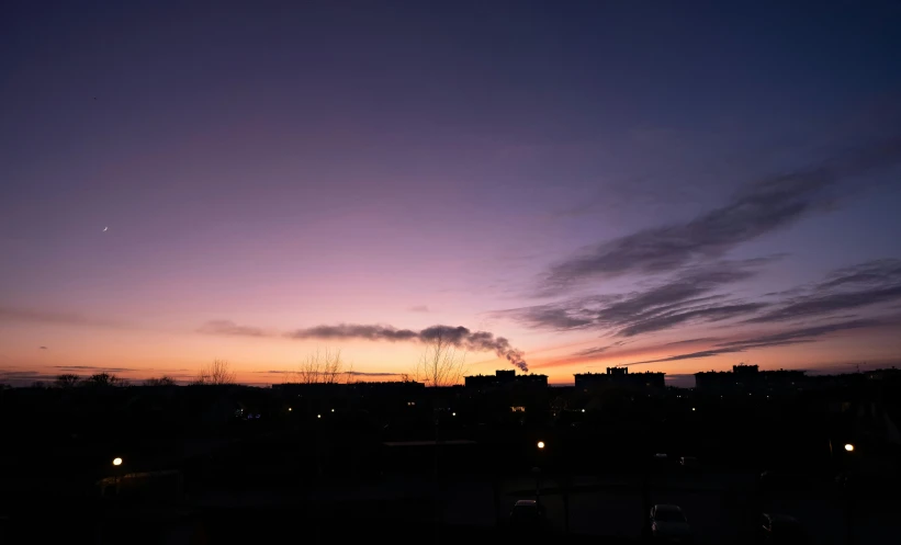 a skyline is shown at night as the sun sets