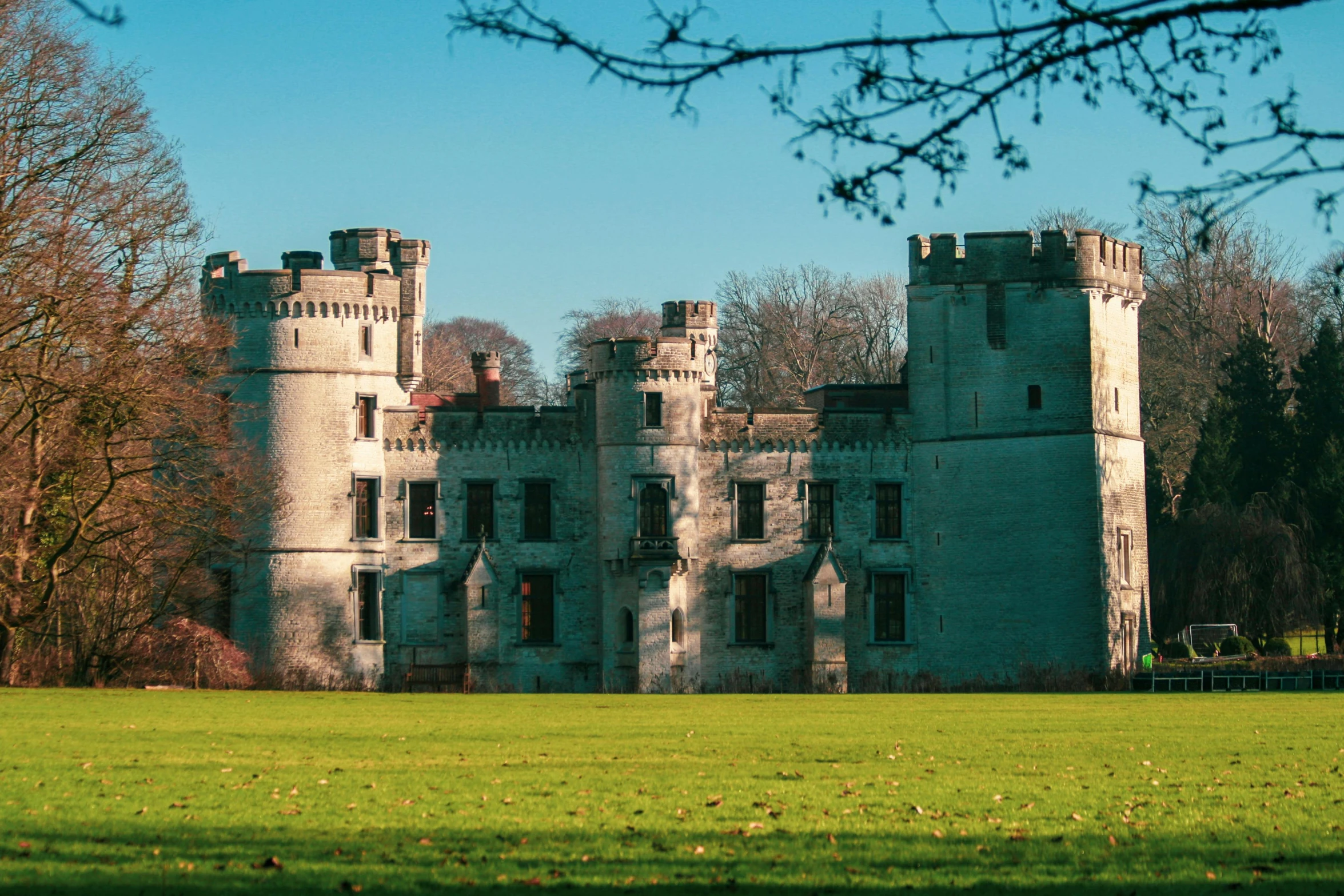 a large castle sitting in the middle of a lush green field