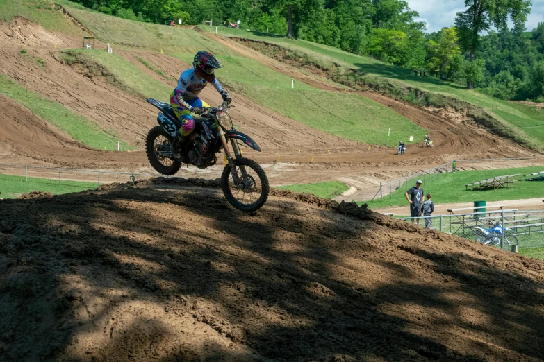 a man riding a motorcycle on top of a dirt hillside