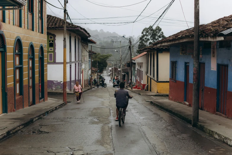 a man rides down a street on a bike