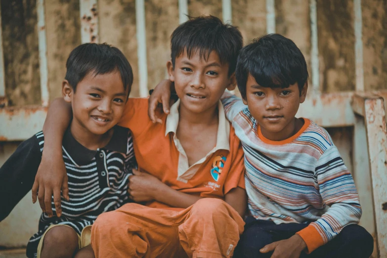 three boys posing for a po and smiling