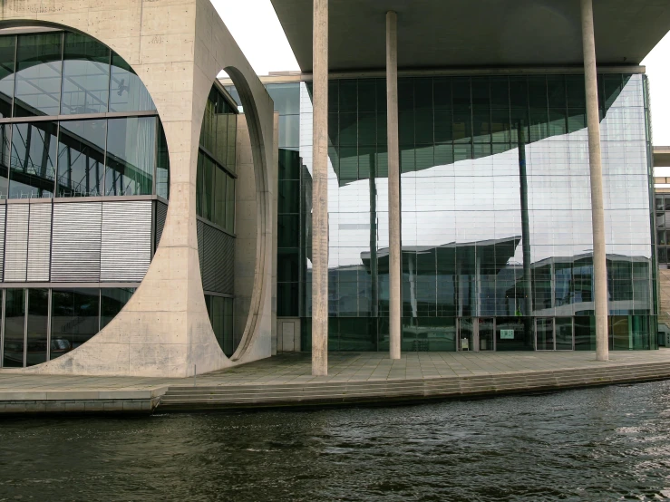 buildings with large circular windows reflecting off the water