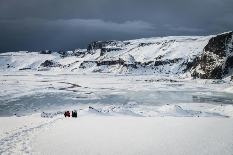 a group of people standing next to each other on top of snow covered ground