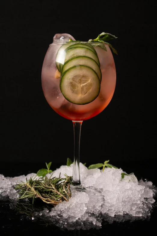 the cocktail is garnished with sliced cucumber