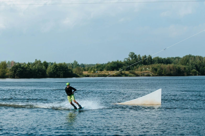 a man in black shirt and hat skiing across water