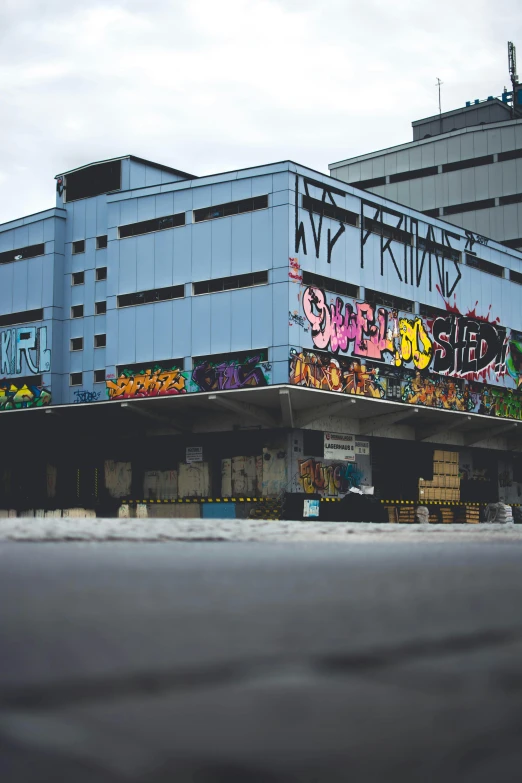 a parking lot with graffiti and buildings behind it