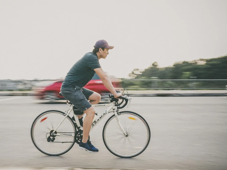 a person riding on the back of a bicycle down a street