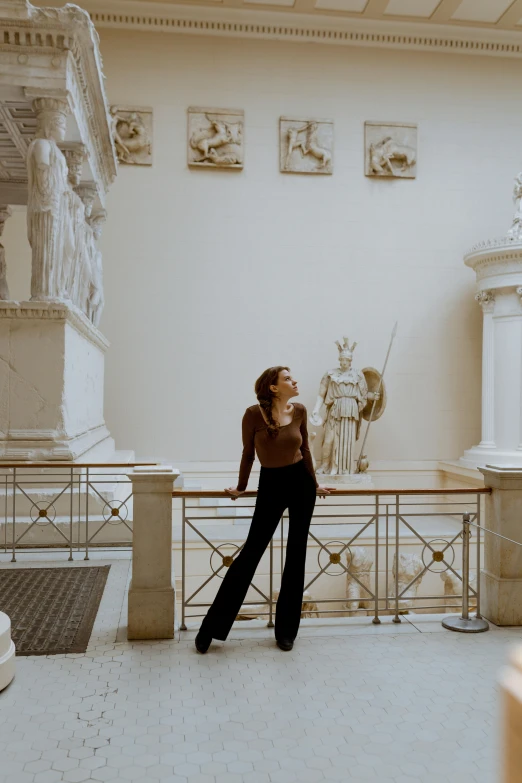 a woman standing on a ledge in a museum