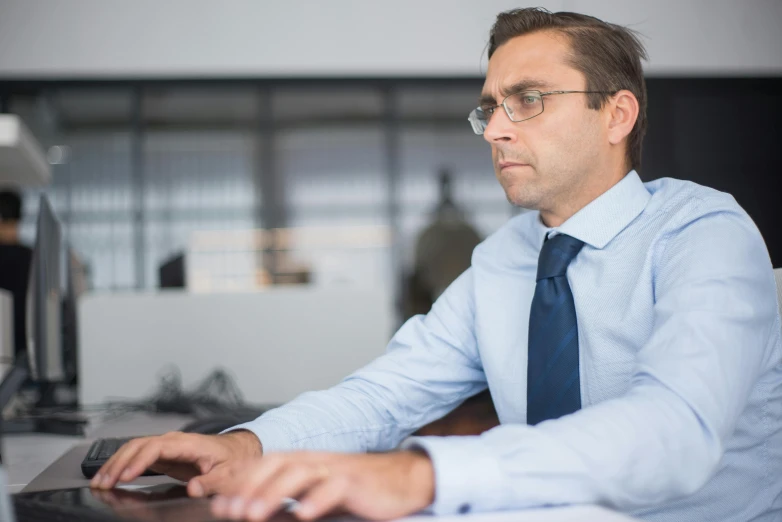 a man sitting at a computer looking at the screen
