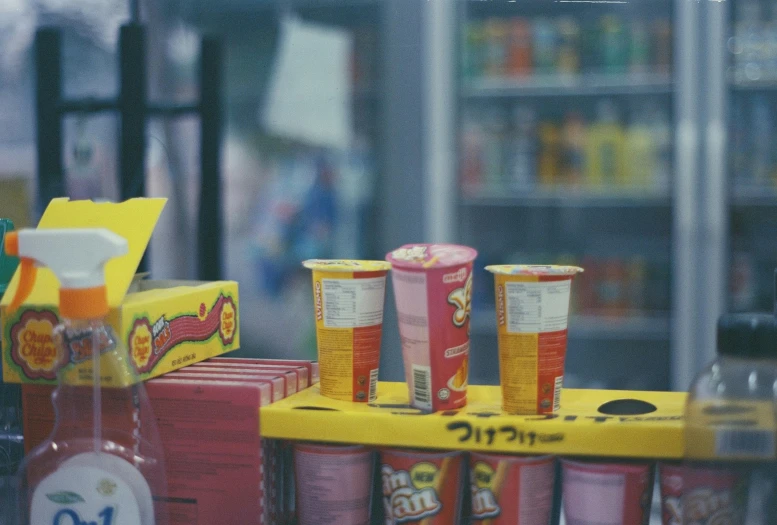 two small soda cans with drinks and a can of mustard