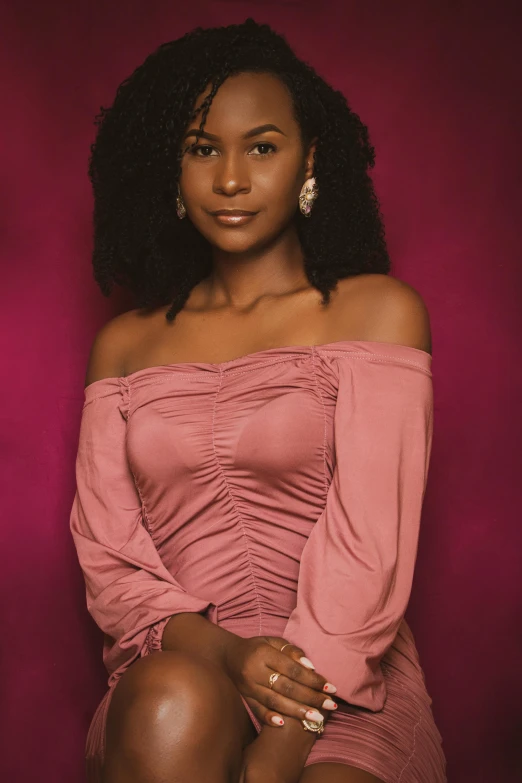 a close - up of a female in a pink dress posing for a picture