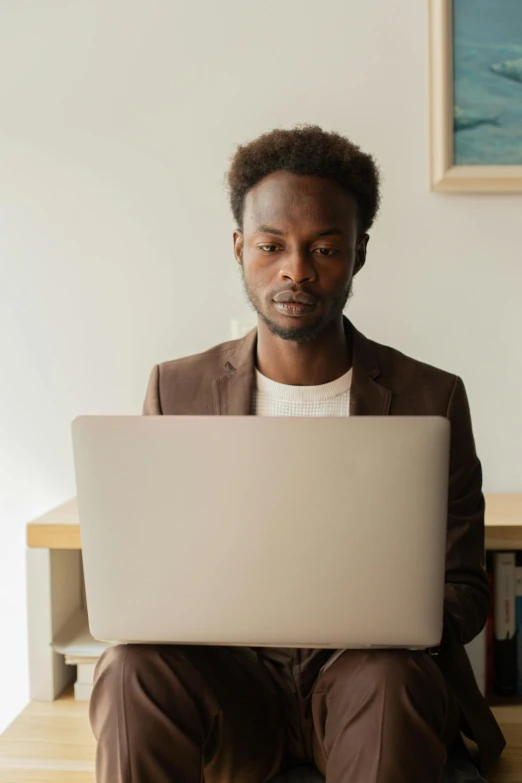 a man sitting with his laptop in front of him