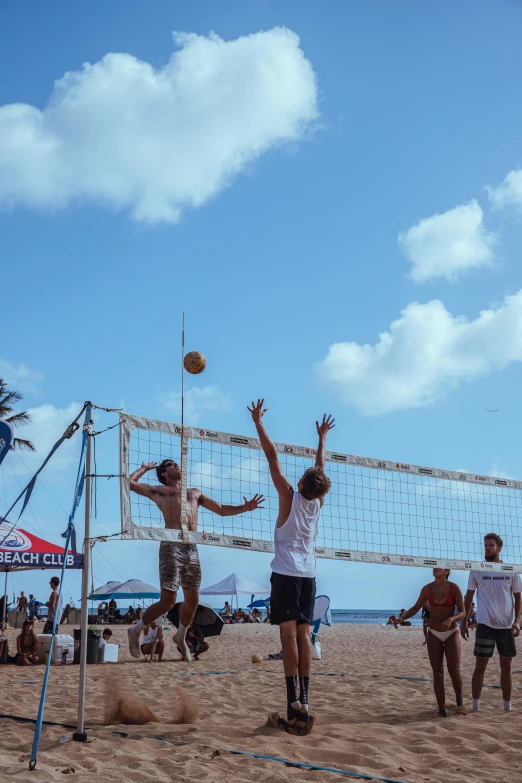 several people are playing volleyball in the sand