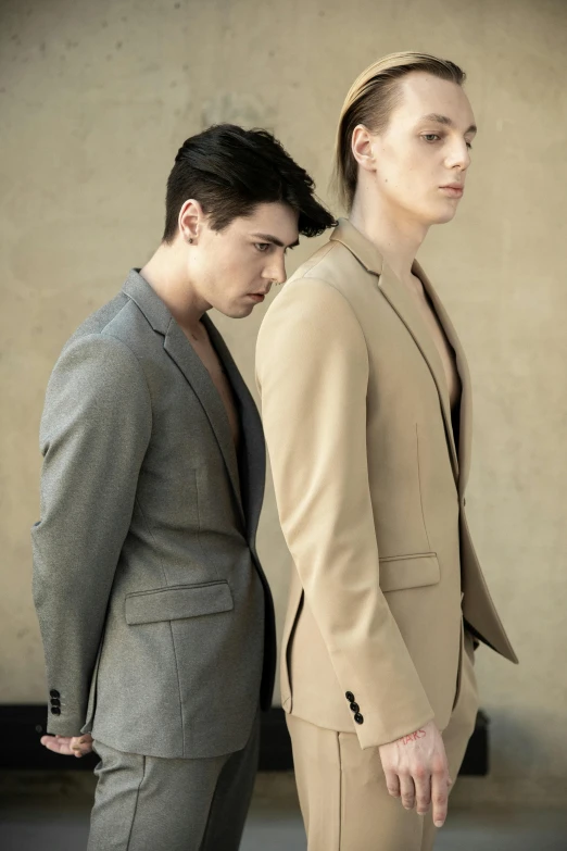 two male models wearing formal looking clothing and one is very short