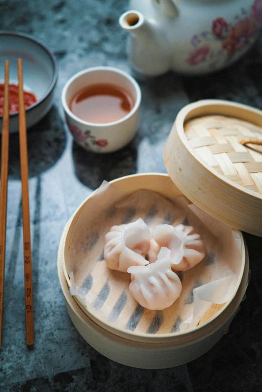 some food in small containers with chop sticks near it