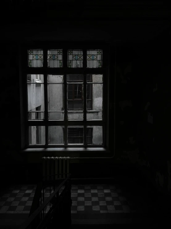 the dark room has an open window and some dark stairs