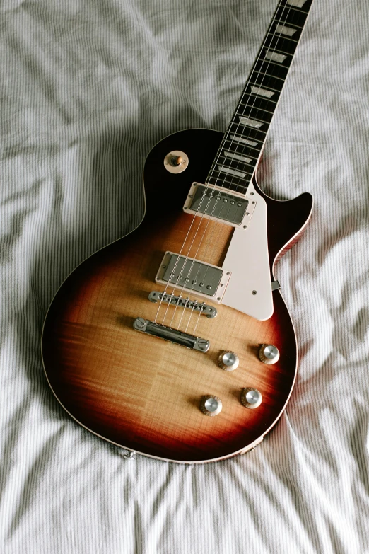 a guitar resting on top of a bed