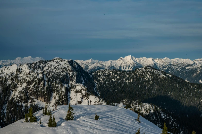 some people on skis stand on the edge of a mountain