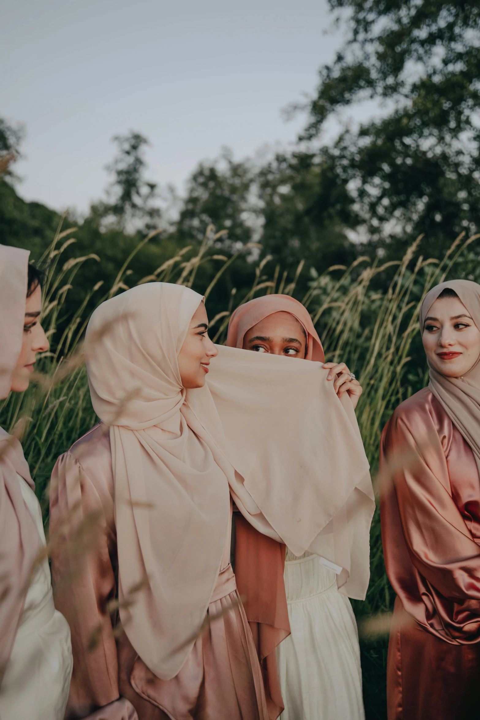 a group of women in hijabs look at each other