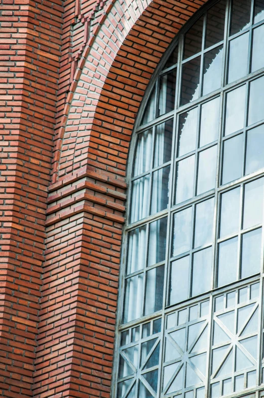 a large red brick wall with a clock mounted to it's side