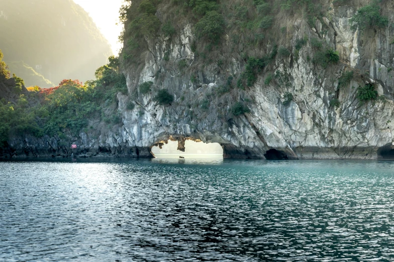 large cave located between two rocks in the water