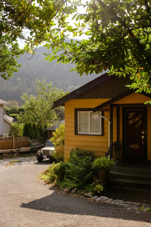 a home with a yellow house surrounded by trees