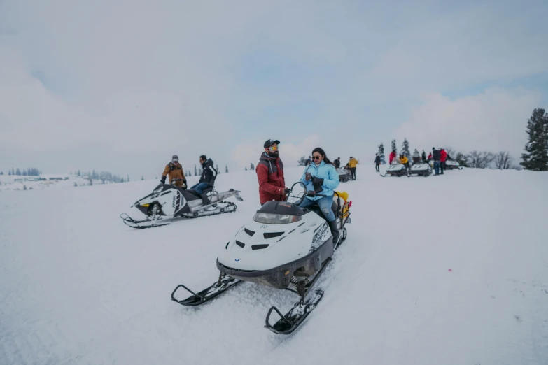 snowmobiles and skiers at the top of the slope