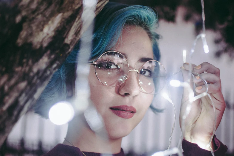 a close up of a person with glasses and blue hair