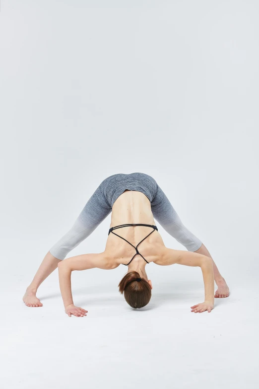 woman doing handstand pose with leg stretched in mid air