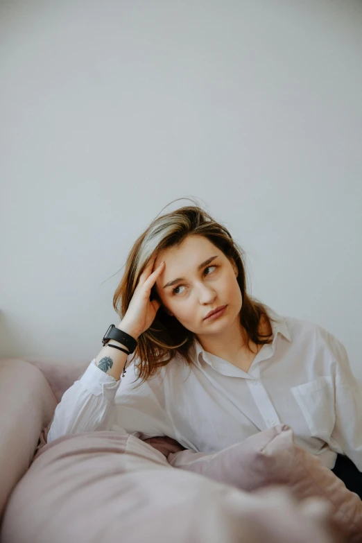 woman sitting on a bed staring off to the side