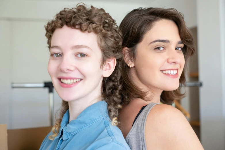 the two woman are standing together and smiling for the camera