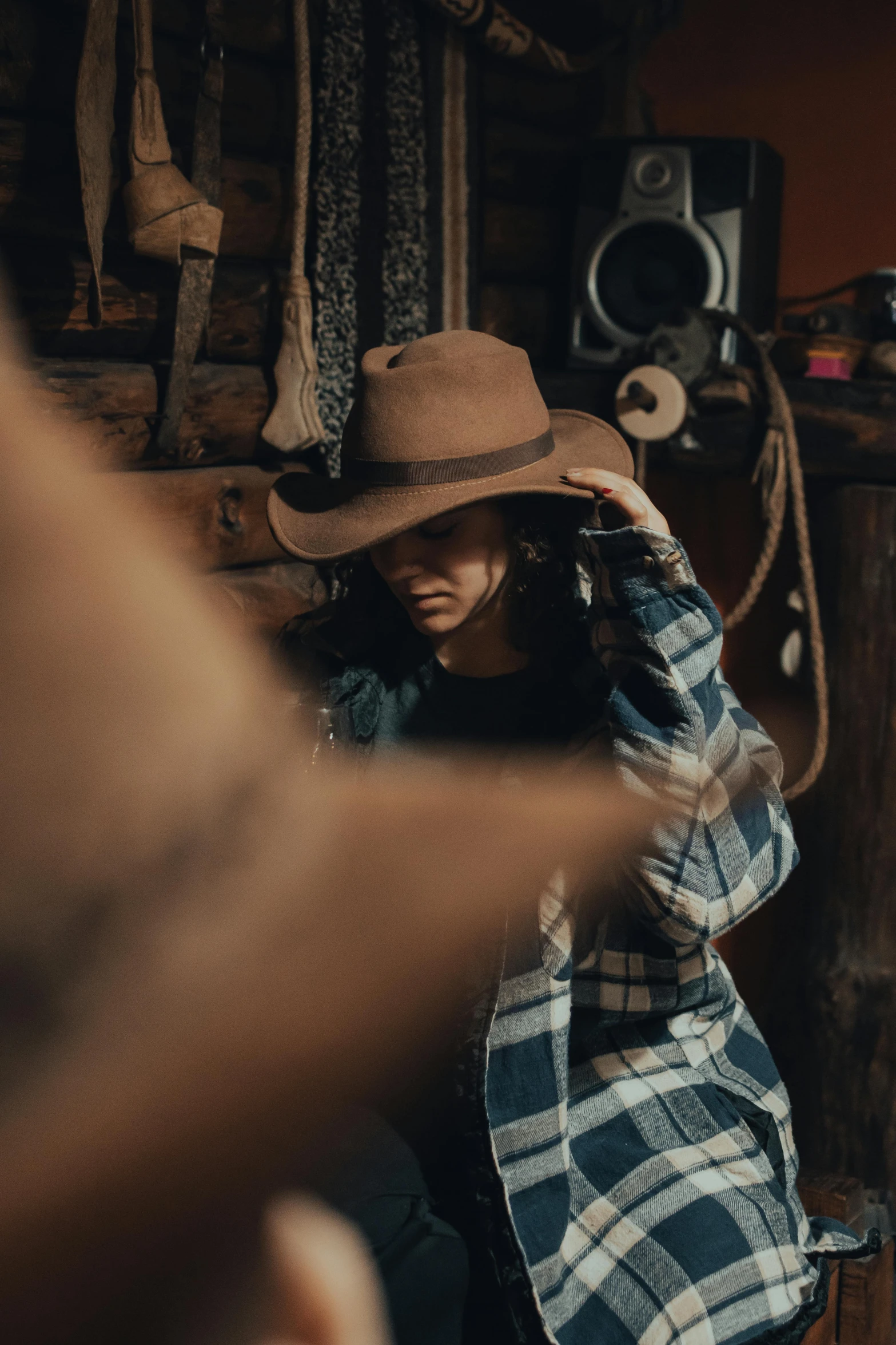 a girl wearing a hat looks into a mirror